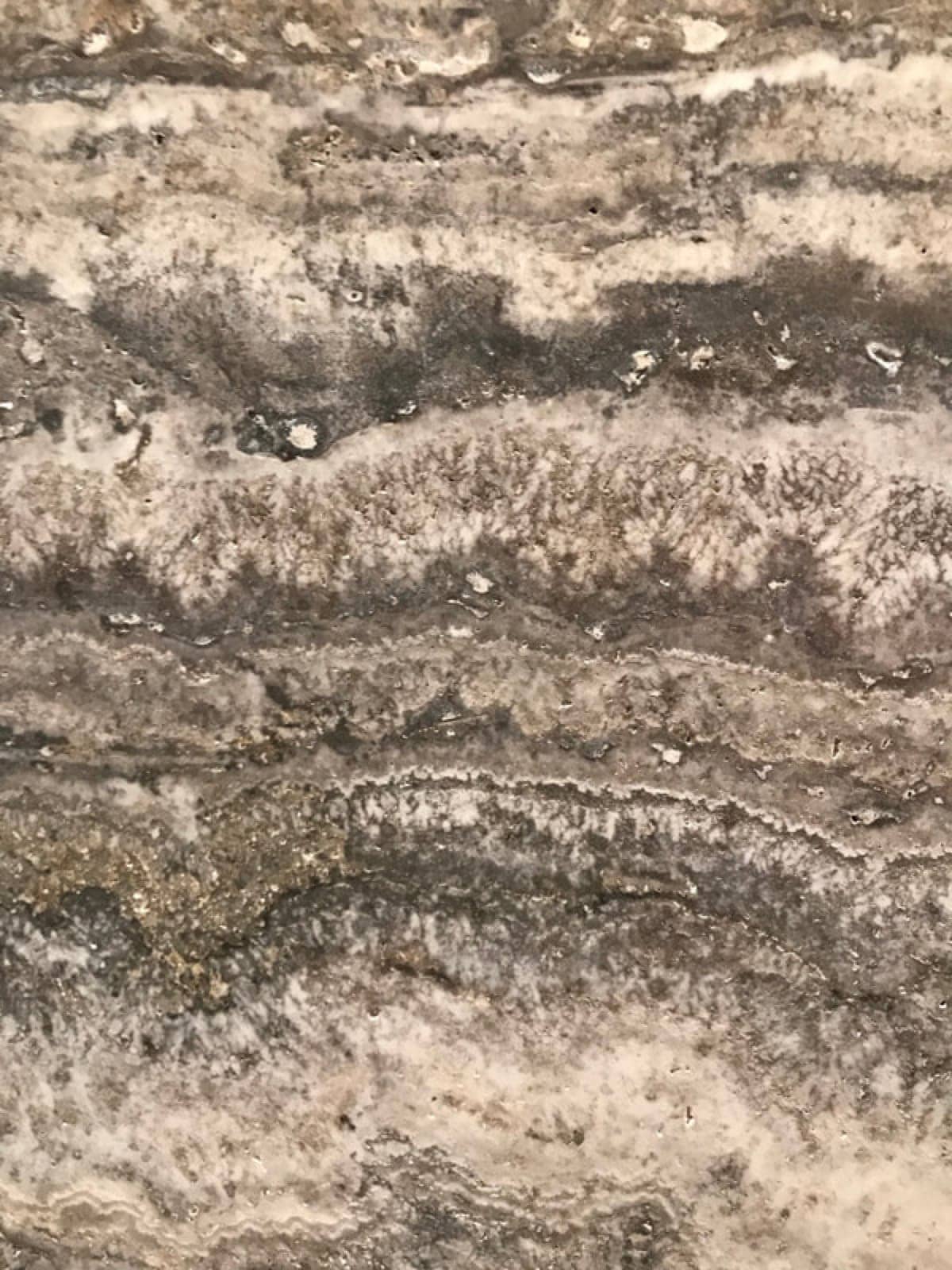 Silver travertine stone surface used as the stone-veneer comparison.